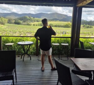 A happy customer is standing on the Deck, drinking in the beautiful scenery and enjoying a cold beer.